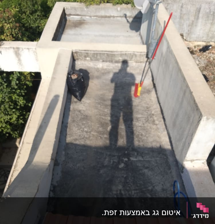 גג עם אנטנה, מטאטא ושקית זבל שחורה